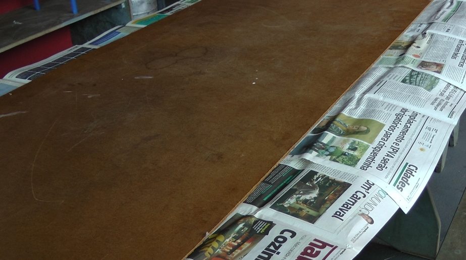 madeira compensado em cima de mesa forrada com jornal