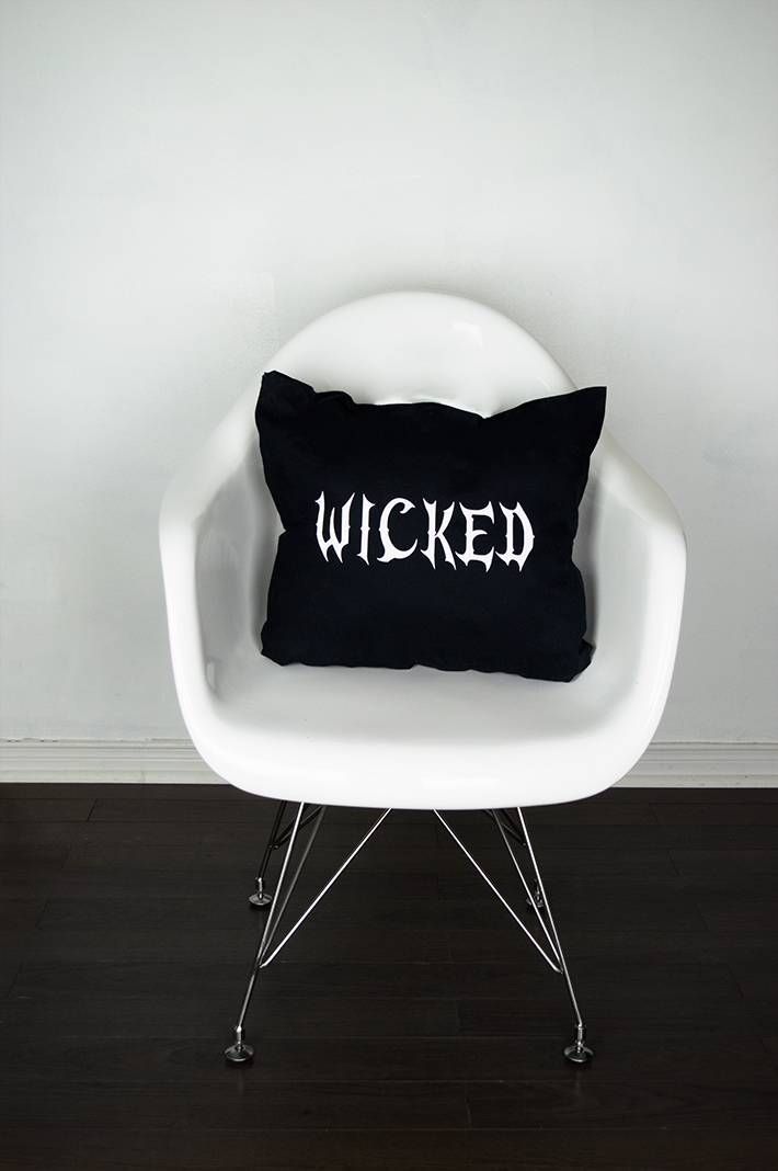 almofada preta em cima da cadeira escrito wicked