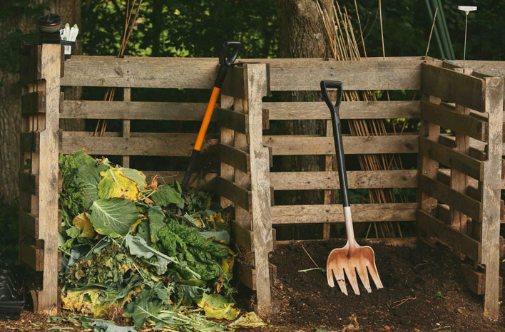 pallets de pé com restos de verduras e ancinho